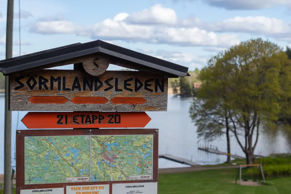 Träskylt med texten Sörmlandsleden och en etappkarta